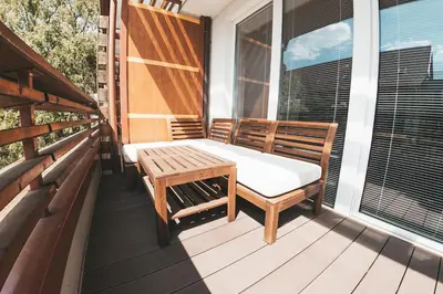 a porch with a bench and a table on a balcony at Stork's Nest - Moravske Toplice in Moravske Toplice