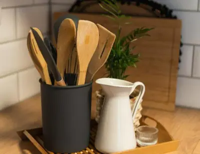 a black cup filled with wooden utensils on a table at Apartment Bohinj with excellent location in Bohinj