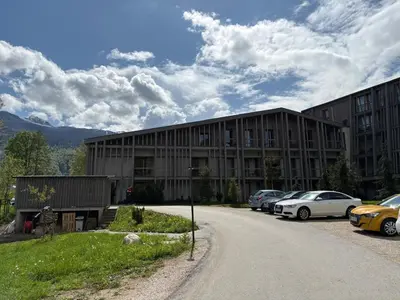 a large building with cars parked in front of it at Apartment Bohinj with excellent location in Bohinj