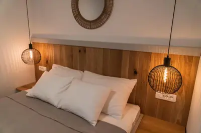 a bed with two pendant lights and a mirror at Apartment Bohinj with excellent location in Bohinj