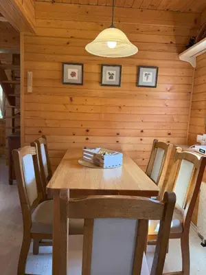 a dining room with a wooden table and chairs at Počitniška hiša z dvema spalnicama Sauna & Jacuzzi in Gorica pri Slivnici