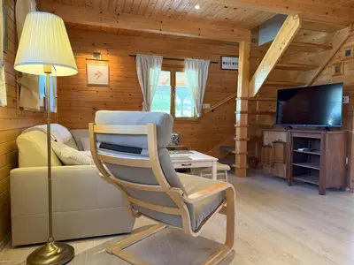 a living room with a chair and a television at Počitniška hiša z dvema spalnicama Sauna & Jacuzzi in Gorica pri Slivnici