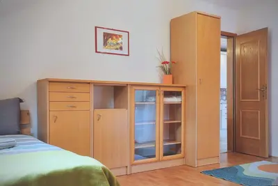 a bedroom with a wooden cabinet and a bed at Apartment Erika in Idrija