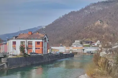 a view of a river with buildings and a mountain at Apartment Erika in Idrija