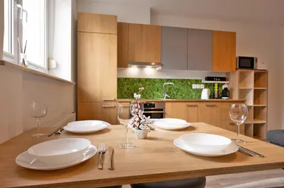 a dining room table with white plates and wine glasses at Apartma Seničica in Ljubljana