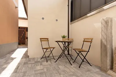 a table and four chairs in a room with a wall at Apartma Seničica in Ljubljana