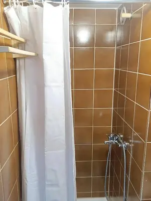 a shower with a white shower curtain in a bathroom at Renovated Apartment for Four in Ljubljana