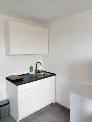 a kitchen with white cabinets and a sink at Renovated Apartment for Four in Ljubljana