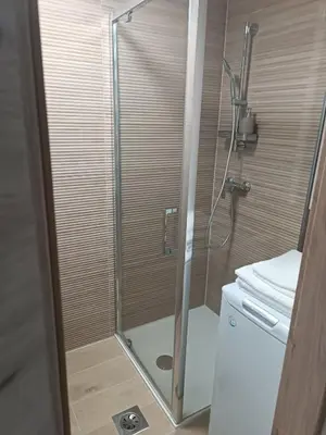 a shower with a glass door in a bathroom at CoCo Apartment in Ljubljana
