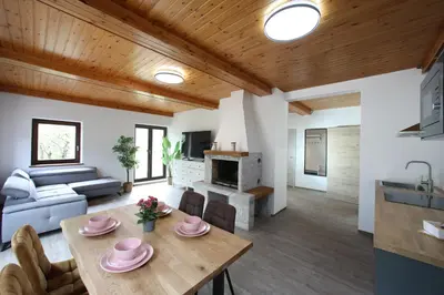 a living room with a table and a couch at Sunset Valley Apartments and Rooms in Bohinj