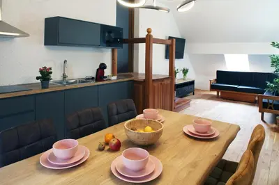 a wooden table with a bowl of fruit on top of it at Sunset Valley Apartments and Rooms in Bohinj