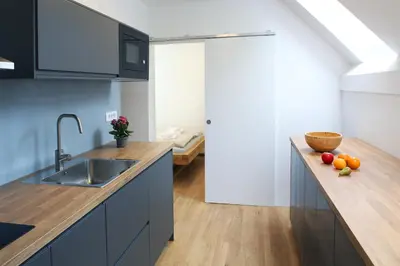 a kitchen with blue cabinets and a wooden counter top at Sunset Valley Apartments and Rooms in Bohinj