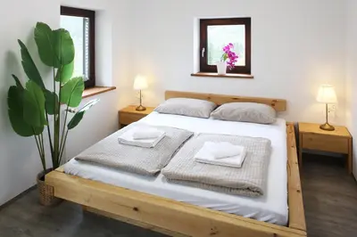 a bedroom with a bed with two towels and a plant at Sunset Valley Apartments and Rooms in Bohinj