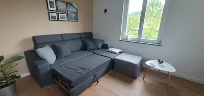a living room with a blue couch and a table at Gala Lenassi in Kamnik