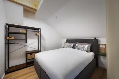 a bedroom with a bed with white sheets and pillows at Family and Friends Apartments Bled in Spodnje Gorje