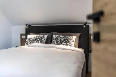 a bedroom with a large white bed with pillows at Family and Friends Apartments Bled in Spodnje Gorje