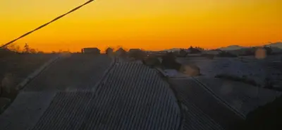 a sunset over a field with the sun setting in the background at Apartma Martin in Miklavž pri Ormožu