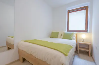 a bedroom with a bed with a green blanket on it at Old Town ground floor in Ljubljana