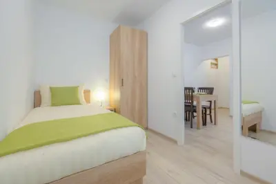 a bedroom with a bed and a dining room at Old Town ground floor in Ljubljana