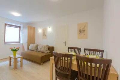 a living room with a table and chairs and a couch at Old Town ground floor in Ljubljana