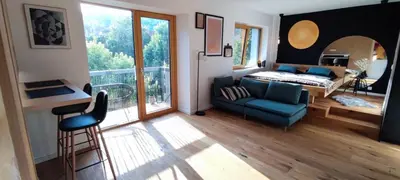 a living room with a blue couch and a large window at Biohacker Ljubljana in Ljubljana