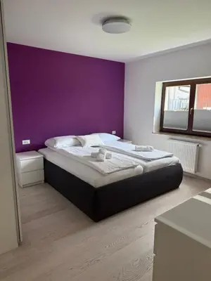 a bedroom with a large bed with a purple wall at My Family Home Bled in Bled