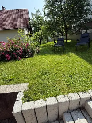 two chairs in a yard with grass and flowers at My Family Home Bled in Bled