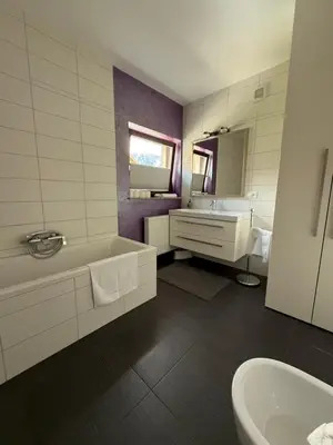 a bathroom with a tub and a sink and a mirror at My Family Home Bled in Bled