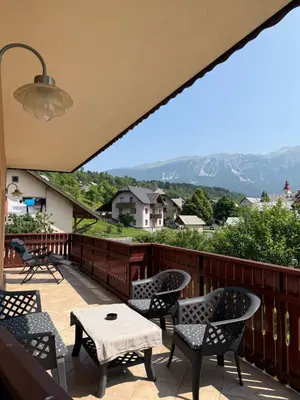 a balcony with chairs and tables and a view of mountains at My Family Home Bled in Bled