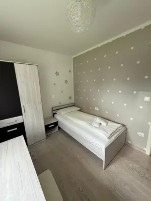 a small bedroom with a bed and a chandelier at My Family Home Bled in Bled