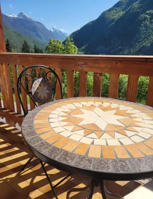 a table on a deck with a view of mountains at Chalet Julian in Žaga