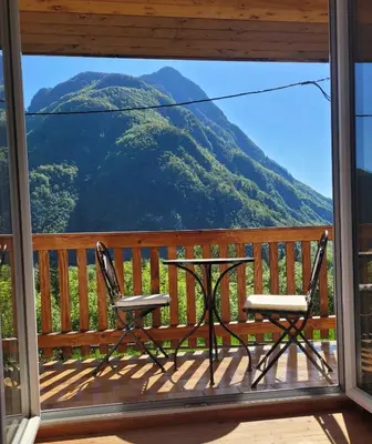 a balcony with a table and chairs and a mountain view at Chalet Julian in Žaga
