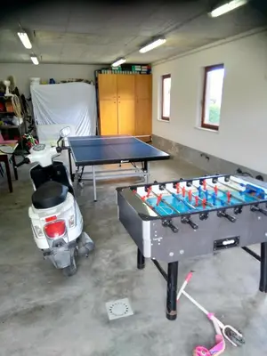 a garage with a ping pong table in it at Gostilna Pension Blegoš in Poljane nad Škofjo Loko