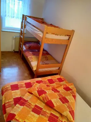 a bedroom with a bunk bed with a quilt at Gostilna Pension Blegoš in Poljane nad Škofjo Loko