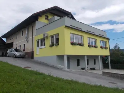a yellow and white building on the side of a road at Gostilna Pension Blegoš in Poljane nad Škofjo Loko