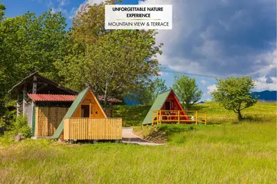 a group of small buildings in a field at Komac Apartma & Glamping BLED in Bled
