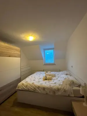 a bedroom with a bed with a teddy bear on it at Komac Apartma & Glamping BLED in Bled
