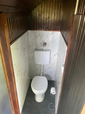 a small bathroom with a white toilet in a room at Komac Apartma & Glamping BLED in Bled