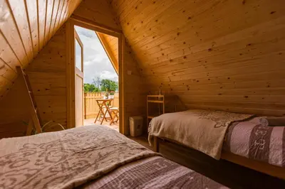 a room with two beds in a wooden cabin at Komac Apartma & Glamping BLED in Bled