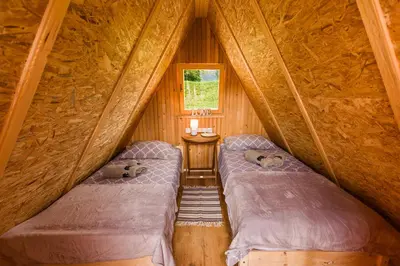 two beds in a small room in a log cabin at Komac Apartma & Glamping BLED in Bled