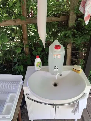 a sewing machine sitting on top of a white sink at LAND FOR YOUR TENT NEXT TO A RIVER WITH A GARDEN SHACK ROOM you get two bicycles for amazing views and two water floats for a nice river run USE THE LOCATION NOT THE ADDRESS TO GET HERE bathroom is a bit different so check YouTube video RiverRunDusko in Ljubljana