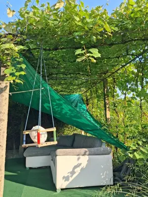 a hammock hanging from a tree with a couch at LAND FOR YOUR TENT NEXT TO A RIVER WITH A GARDEN SHACK ROOM you get two bicycles for amazing views and two water floats for a nice river run USE THE LOCATION NOT THE ADDRESS TO GET HERE bathroom is a bit different so check YouTube video RiverRunDusko in Ljubljana