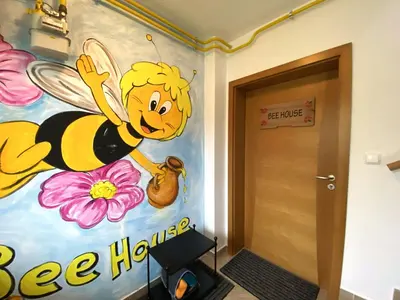 a wall mural of a bee holding a flower at Bee Apartment in Bohinj