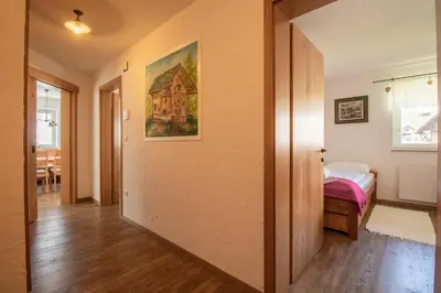 a hallway with a bedroom and a bed in a room at Bee Apartment in Bohinj