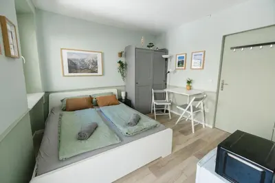 a small bedroom with a bed and a table at Castle Road Bled in Bled