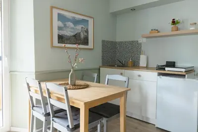 a dining room table with chairs and a vase with flowers on it at Castle Road Bled in Bled