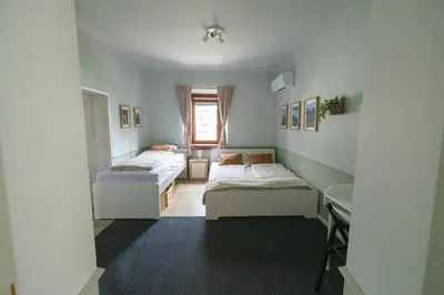 a room with two beds and a desk in it at Castle Road Bled in Bled