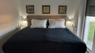a bedroom with a bed with two pillows and a window at Villa AMULET in Postojna