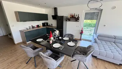 a kitchen and dining room with a table and chairs at Villa AMULET in Postojna