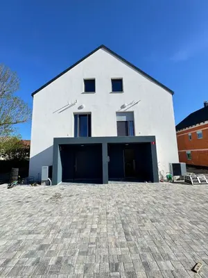 a white building with two garage doors in front at Villa AMULET in Postojna
